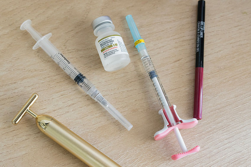 A young woman with blonde hair smiles at the camera, set against a backdrop of a palm tree shadow cast on a wall.