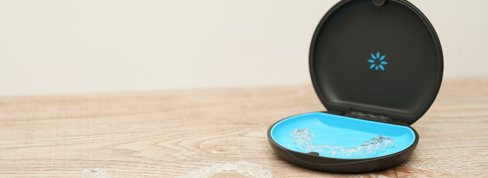 A black smartphone case with a blue circular cutout on a wooden surface.