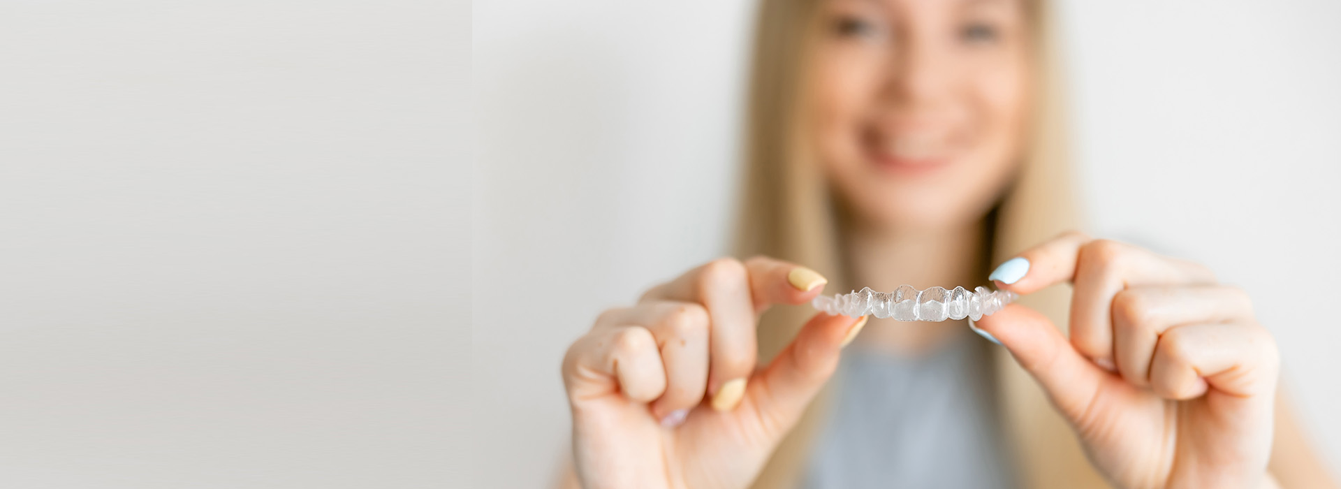 The image shows a person holding up a small object with both hands, positioned against a plain background.