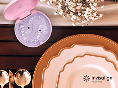 An advertisement featuring a table setting with plates, a box of cosmetic product, and a text overlay indicating  Invisalign  and  Visionplan.